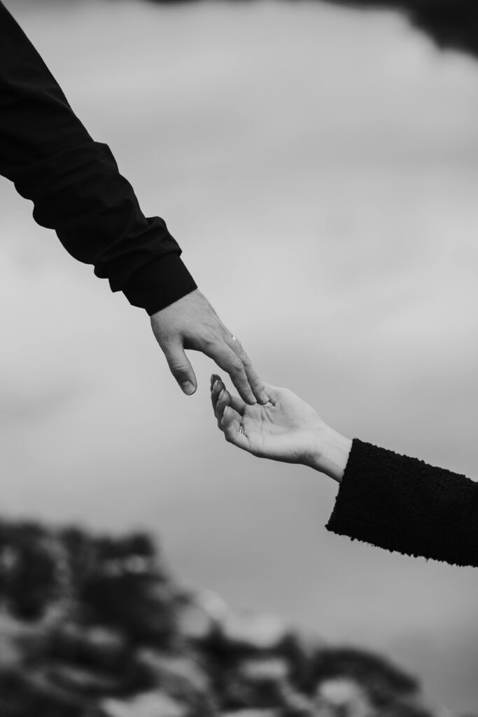 A touching black and white photograph capturing two hands reaching towards each other symbolizing connection.